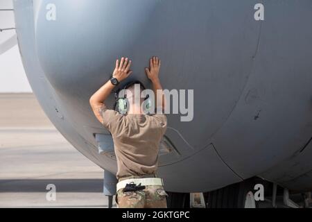 Un Airman de la Force aérienne des États-Unis de 1re classe Austin Lockhart, 380e chef d'équipage de l'escadron de maintenance des aéronefs expéditionnaires, Al Dhafra Air base, Émirats arabes Unis, donne de bonnes vibes à un aéronef Compass Call EC-130H avant le décollage le 29 juin 2021. Les membres qui soutiennent actuellement la mission Compass Call de l'ADAB sont déployés en tant qu'équipe de la base aérienne de Davis-Monthan, à Tucson, en Arizona, ce qui signifie qu'ils travaillent le même horaire pendant la durée de leur déploiement, ce qui favorise le moral et la camaraderie, et optimise l'efficacité de l'équipe. Banque D'Images