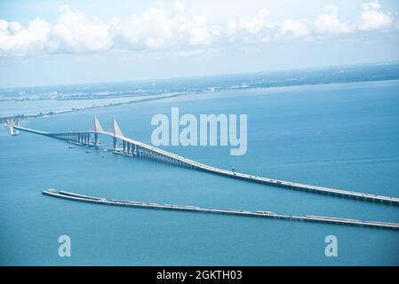 La vue du pont Sunshine Skyway, en tant que C-130 de la station aérienne de la Garde côtière, Clearwater effectue une mission d'entraînement, Tampa Bay (Floride), le 29 juin 2021. Au cours de la mission, l'équipage a effectué des opérations d'entraînement en vol et a laissé des fournitures d'urgence simulées à une cible située à 12 milles à l'ouest d'Anclote Key. (. Banque D'Images