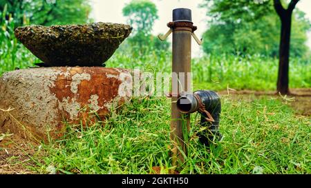 Vieux nylon noir plastique pvc tuyaux d'eau vannes équipement installé dans les tranchées de terre pour l'irrigation photo de gros plan. Banque D'Images