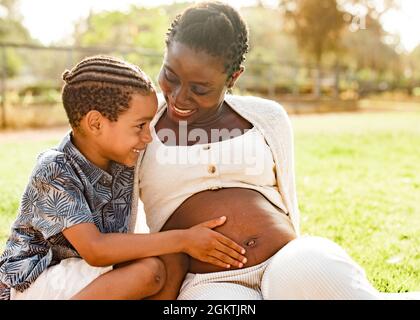 Garçon noir touchant le ventre de la femme enceinte Banque D'Images