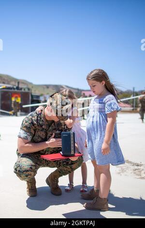 Le petit officier de 2e classe Joseph Hardebeck, un corpman de Battery A., 1er Bataillon, 11th Marines, 1re Division Marine, présente sa Médaille du coeur pourpre à ses filles au camp de base du corps des Marines Pendleton, Californie, 1er juillet 2021. Hardebeck a reçu la Médaille du cœur violet pour ses blessures subies à l'appui de l'opération Enduring Freedom. Banque D'Images