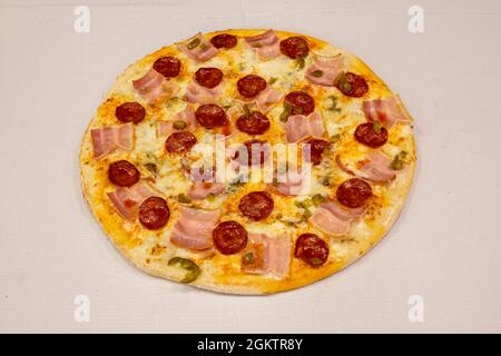 Pizza mexicaine au bacon, chorizo épicé, mozzarella et jalapenos sur carton blanc Banque D'Images