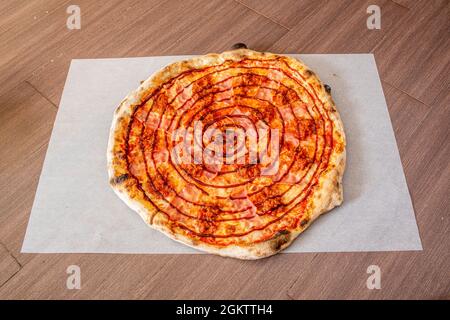 Pizza à croûte mince avec bacon et recette de sauce barbecue sur papier sulfurisé blanc Banque D'Images