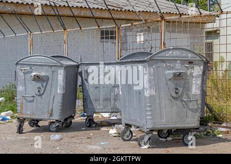 Trois poubelles à roues métalliques sur le site industriel Banque D'Images