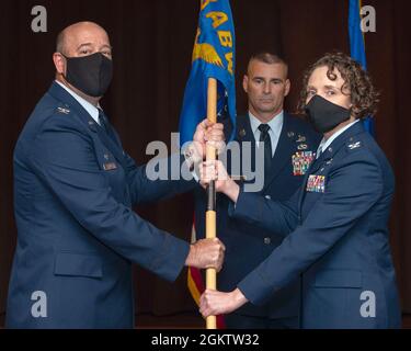 Le colonel Patrick Miller, 88e Escadre de la base aérienne et commandant de l'installation, présente les lignes directrices du 88e Groupe de soutien à la mission au colonel Sirena Morris, alors qu'elle prend le commandement lors d'une cérémonie de changement de commandement le 1er juillet 2021 dans le club de la base aérienne Wright-Patterson, Ohio. Banque D'Images