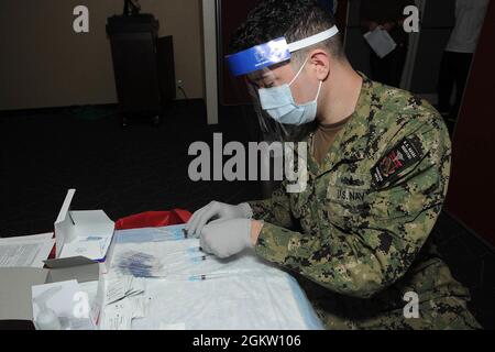 ATSUGI, Japon (2 juillet 2021) Hôpital Corpsman 3e classe Johnathan Norton, affecté à l'unité de préparation et de formation à la médecine navale (NMRTU) Atsugi, Japon, organise des seringues avant d'administrer la vaccination Moderna COVID-19 aux employés de la région à bord de l'installation aérienne navale (NAF) Atsugi, 2 juillet. Les vaccins proviennent de la fourniture par l'USFJ de vaccins approuvés, offerts à ceux qui choisissent des recevoir, dans un effort pour prévenir la propagation de la COVID-19 et pour assurer la capacité de l'USFJ de soutenir la sécurité du Japon. Banque D'Images