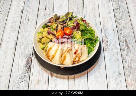 Bocal à poke végétalien avec d'épaisses tranches de tofu, avocat avec salsa, oignon rouge, tomates cerises, pousses de laitue et salade d'algues wakame Banque D'Images