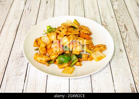 une délicieuse recette de poulet de style taï cuisinée dans un wok avec des légumes sautés variés Banque D'Images