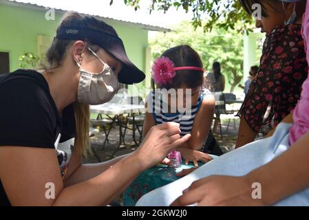 Anne Herrmann, capitaine de la US Air Force, directrice du protocole avec la joint Task Force-Bravo (JTF-B), peint les ongles d'une jeune fille lors d'une visite à l'orphelinat de Nuestra Señora de Guadalupe à Comayagua, au Honduras, le 3 juillet 2021. Depuis 1997, la foi-B a soutenu la communauté locale et plus de 700 enfants dans plusieurs orphelinats de la vallée de Comayagua. Banque D'Images