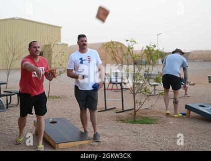 Les membres du service affectés au 724e Escadron de la base aérienne expéditionnaire participent à un tournoi de cornhole le 4 juillet 2021 à la base aérienne 201, au Niger. Les membres ont participé à un tournoi de basket-ball, de volley-ball et de cornhole, ainsi qu'à un bingo et à un concours le mieux habillé pour célébrer le jour de l'indépendance. Banque D'Images