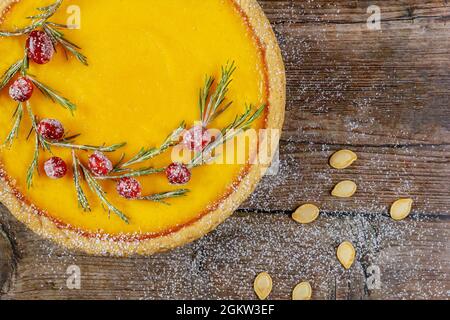 Gros plan de tarte à la citrouille décorée de canneberges sur fond rustique, vue du dessus. Banque D'Images