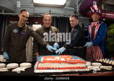 210704-N-UF592-1010 MER D'ARABIE (le 4 juillet 2021) - de gauche à droite, le capitaine Matthew Ventimiglia, dirigeant du porte-avions USS Ronald Reagan (CVN 76), le capitaine Fred Goldhammer, commandant de Ronald Reagan, le CMDCM Christopher King, chef de commandement de Ronald Reagan, et le lieutenant Cmdr. Rob Allen, l’adjoint de l’approvisionnement de Ronald Reagan, a coupé un gâteau lors d’une célébration du jour de l’indépendance dans les ponts arrière du mess de Ronald Reagan en mer d’Arabie, le 4 juillet. Le groupe de grève des transporteurs Ronald Reagan est déployé dans la zone d'opérations de la 5e flotte des États-Unis pour soutenir les opérations navales et fournir airpo Banque D'Images