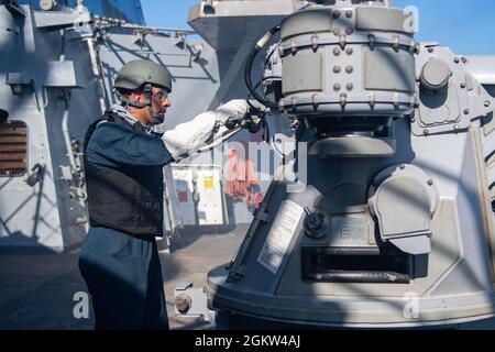 OCÉAN ATLANTIQUE (4 juillet 2021) – le Matelot de 1re classe de Gunner, Zaid GonzálezPortillo, affecté au destroyer à missiles guidés de la classe Arleigh Burke USS Laboon (DDG 58), lance un fusil Mark 38, Mod 2, de 25 mm dans l’océan Atlantique, le 4 juillet 2021. Laboon est en cours de déploiement de routine dans la zone d'opérations de la Sixième flotte des États-Unis afin de soutenir les intérêts nationaux et la sécurité des États-Unis en Europe et en Afrique. Banque D'Images