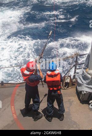 MER DE CHINE ORIENTALE (6 juillet 2021) les marins se préparent à tirer une ligne du destroyer de missile guidé de la classe Arleigh Burke USS John S. McCain (DDG 56) au navire de cargaison sèche de la classe Lewis et Clark USNS Alan Shepard (T-AKE 3) lors d'une reconstitution en mer. McCain est affecté à la Force opérationnelle 71/escadrille de Destroyer (DESRON) 15, la plus grande force DESRON de la Marine et la principale force de surface de la 7e flotte américaine. Banque D'Images