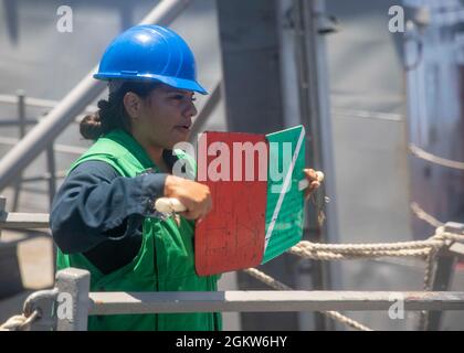 MER DE CHINE ORIENTALE (6 juillet 2021) Rebecca Rocha, Matelot de 1re classe Boatswain, signale au navire de fret sec de classe Lewis et Clark USNS Alan Shepard (T-AKE 3) à bord du destroyer de missile guidé de classe Arleigh Burke USS John S. McCain (DDG 56) lors d’un réapprovisionnement en mer. McCain est affecté à la Force opérationnelle 71/escadrille de Destroyer (DESRON) 15, la plus grande force DESRON de la Marine et la principale force de surface de la 7e flotte américaine. Banque D'Images