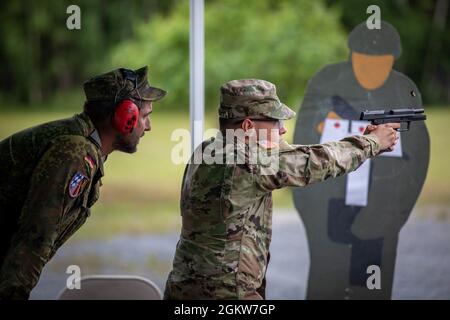Sergent de l'armée allemande 1re classe Patrick Krausse, à gauche, un officier de la sécurité du contrôle de l'aire de répartition, agit comme un agent de sécurité tandis que le Cpl de l'armée américaine. Frank Halstead, spécialiste des ressources humaines, attaché au 7e Commandement de l'entraînement de l'Armée, se livre à l'insigne des Forces armées allemandes du Marksmanship 'chutzenschnur', avec un pistolet P8 allemand au Range 114, zone d'entraînement de Grafenwoehr, Allemagne le 7 juillet 2021. Les soldats américains qui réussissent le concours reçoivent le Schutzenschnur au niveau bronze, argent ou or, selon la précision d’un soldat. Banque D'Images