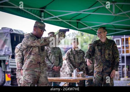 SPC de l'armée américaine. David Gregory, à gauche, un officier de police militaire attaché à la 615e compagnie de police militaire, se familiarise avec le pistolet P8 allemand avec l'aide du PFC de l'armée allemande. Werner Fellner, à droite, officier de la sécurité du contrôle de l'aire de répartition, avant de se disputer l'insigne des forces armées allemandes du Marksmanship 'Schutzenschnur' le 7 juillet 2021, au Range 114, zone d'entraînement de Grafenwoehr, Allemagne. Les soldats américains qui réussissent le concours reçoivent le Schutzenschnur au niveau bronze, argent ou or, selon la précision d’un soldat. Banque D'Images