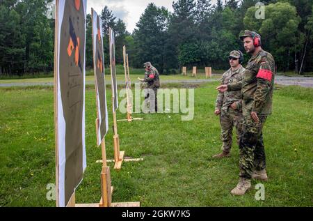 Sergent de l'armée allemande 1ère classe Patrick Krausse, à droite, un officier de la sécurité du contrôle de l'aire de répartition, et le SPC de l'armée américaine. Harley Mischel, un officier de police militaire, examine une cible tandis que Mischel concurrence pour l'insigne des forces armées allemandes de la stratégie de Marksmanship 'Schutzenschnur' avec un pistolet P8 allemand à la gamme 114, zone d'entraînement de Grafenwoehr, Allemagne le 7 juillet 2021. Les soldats américains qui réussissent le concours reçoivent le Schutzenschnur au niveau bronze, argent ou or, selon la précision d’un soldat. Banque D'Images