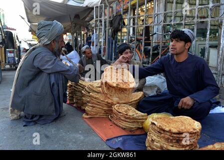 (210915) -- KANDAHAR, le 15 septembre 2021 (Xinhua) -- un vendeur afghan vend de la nourriture aux consommateurs de la ville de Kandahar, dans le sud de l'Afghanistan, le 14 septembre 2021. POUR ALLER AVEC:' Roundup: Les Afghans sont loin d'être meilleurs pendant que le gouvernement taliban parvient à diriger un pays avec des appels à l'aide internationale' (photo de Sanaullah Seiam/Xinhua) Banque D'Images