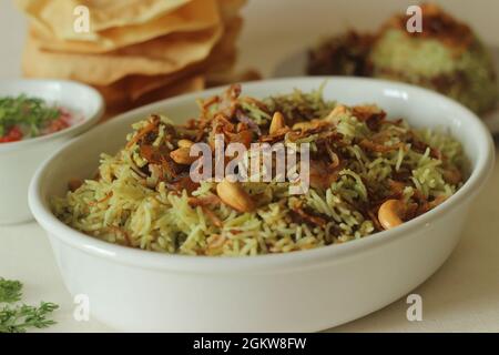 Biriyani vert. Il est fait avec du riz basmati bouillante avec de la pâte de chutney à la coriandre verte et des épices, puis il est superposé avec du poulet au curry et du carameliz Banque D'Images