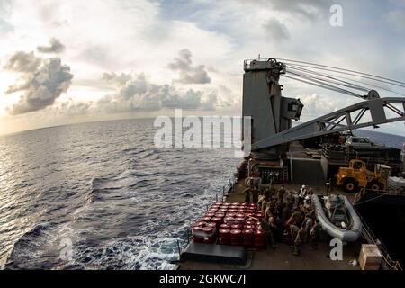 Les marins américains et les marins à bord de l'USS Germantown (LSD 42) déplacent des bidons d'huile lubrifiante lors d'un réapprovisionnement en mer (RAS) dans l'océan Pacifique, le 8 juillet 2021. Un RAS permet aux navires d'obtenir des marchandises essentielles sans les tirer dans le port. La 31e unité expéditionnaire maritime opère à bord de navires du groupe America Expeditionary Ready dans la zone d'opérations de la 7e flotte américaine afin d'améliorer l'interopérabilité avec les alliés et les partenaires et de servir de force de réaction prête pour défendre la paix et la stabilité dans la région Indo-Pacifique. Banque D'Images