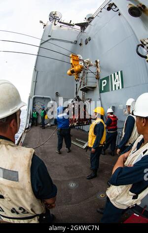 Les marins de la marine américaine à bord de l'USS Germantown (LSD 42) retirent les bidons d'huile lubrifiante du Tippecanoe de l'USNS lors d'un réapprovisionnement en mer (RAS) dans l'océan Pacifique, le 8 juillet 2021. Un RAS permet aux navires d'obtenir des marchandises essentielles sans les tirer au port pour qu'ils puissent poursuivre leurs opérations dans les zones qui leur sont attribuées. La 31e unité expéditionnaire maritime opère à bord de navires du groupe America Expeditionary Ready dans la zone d'opérations de la 7e flotte américaine pour améliorer l'interopérabilité avec les alliés et les partenaires et servir de force de réaction prête à défendre la paix et la stabilité dans le reg Indo-Pacifique Banque D'Images