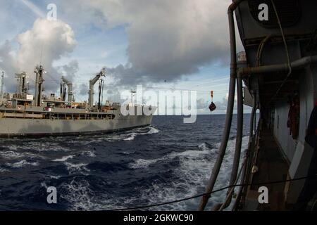 Les bidons d'huile lubrifiante sont déplacés de USNS Tippecanoe (T-AO 199) à USS Germantown (LSD 42) lors d'un réapprovisionnement en mer (RAS) dans l'océan Pacifique, le 8 juillet 2021. Un RAS permet aux navires d'obtenir des marchandises essentielles sans les tirer au port pour qu'ils puissent poursuivre leurs opérations dans les zones qui leur sont attribuées. La 31e unité expéditionnaire maritime opère à bord de navires du groupe America Expeditionary Ready dans la zone d'opérations de la 7e flotte américaine afin d'améliorer l'interopérabilité avec les alliés et les partenaires et de servir de force de réaction prête pour défendre la paix et la stabilité dans la région Indo-Pacifique. Banque D'Images