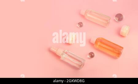 Groupe de bouteilles de cosmétiques avec crème et produits liquides. Kit de voyage, plat. Jolie couleur rose, grande bannière. Banque D'Images