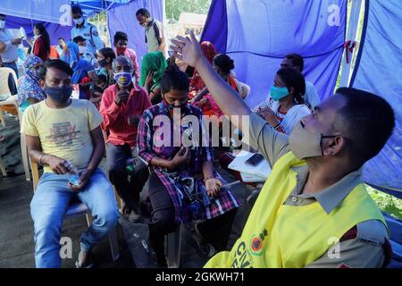 New Delhi, Inde. 15 septembre 2021. Les bénéficiaires s'assoient dans une zone d'observation après avoir reçu le vaccin Covaxin Covid-19 lors d'un camp de vaccination spécial dans la zone de cluster à New Delhi. Ce camp spécial a été organisé pour les sans-abri et les pauvres qui vivent en dessous du seuil de pauvreté. Crédit : SOPA Images Limited/Alamy Live News Banque D'Images