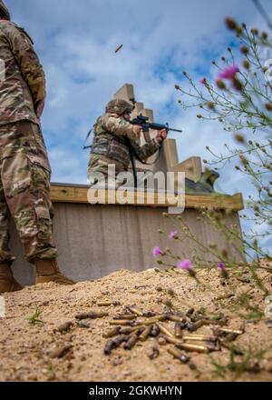 Un soldat tire à partir de la position agenouillée à une aire de répartition cible en bas à fort Devens, Massachusetts, le 10 juillet 2021. Pour de nombreux membres du quartier général de la Force interarmées de la Garde nationale du Connecticut et de la communauté de la police militaire, c'était la première fois qu'ils dirigeaient le nouveau cours de qualification de fusil de l'Armée de terre. Banque D'Images