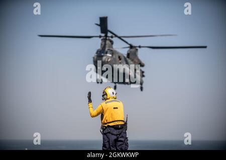 210711-N-KZ419-1519 GOLFE PERSIQUE (le 11 juillet 2021) – le compagnon de bateau d'aviation (manutention) de 3e classe Lauren Bryan, affecté à la base maritime expéditionnaire USS Lewis B. Puller (ESB 3), envoie un signal à un hélicoptère Chinook de la Royal Air Force des Émirats arabes Unis atterrissant sur le pont de vol pendant les opérations de vol dans le golfe Arabo-Persique, Juillet 11. Lewis B. Puller est déployé dans la zone d'opérations de la 5e flotte des États-Unis à l'appui des opérations navales afin d'assurer la stabilité et la sécurité maritimes dans la région centrale, reliant la Méditerranée et le Pacifique par l'océan Indien occidental et trois points d'étranglement stratégiques. Banque D'Images