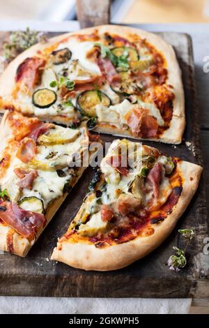 Pizza maison avec artichauts, jambon de parme et courgettes Banque D'Images