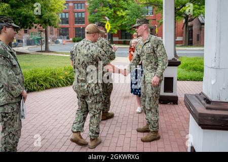 WASHINGTON, DC (12 juillet 2021) – Maître en armes 2e classe Tyrell Dugre, à droite, reçoit des félicitations de ses collègues après son enrôlement dans la Marine américaine. Banque D'Images