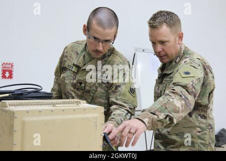 L’Adjudant-chef 2 Anthony Meneely, à droite, technicien en guerre électronique de la Force opérationnelle Phoenix, instruit le SPC. Curtis Hicks, de la Garde nationale du Tennessee, 1er Bataillon d'artillerie de campagne, sur l'exploitation d'un système de guerre improvisée contre-commandé par radio à dispositif explosif (ÉQUIPAGE) au Camp Buehring, au Koweït. Banque D'Images