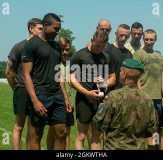 Forces terrestres polonaises, 15e Commandant de brigade mécanisé, Brig. Le général Bogdan Rycerski félicite l'équipe de relais Pologne 4 X 400 mètres du Battle Group pour avoir remporté la deuxième place au Stadion Miejski MOSIR à Giżycko, Pologne le 13 juillet 2021. Le groupe de combat Pologne comptait 40 concurrents représentant l'armée des États-Unis, l'armée britannique et les forces terrestres roumaines pour participer à l'épreuve sur piste et sur le terrain, qui comprenait des courses de 100 mètres, 400 mètres, 800 mètres et 4 X 400 mètres ainsi que des compétitions de lancer de javelot, de tir et de saut long. L'événement inaugral multinational de piste et de terrain a eu lieu pour célébrer la terre polonaise pour Banque D'Images
