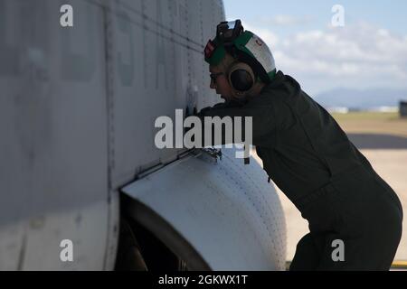 Caporal de lance du corps des Marines des États-Unis Benjamin Reinhardt, chargé de charge au Marine Aerial Refueler transport Squadron (VMGR) 152, inspecte un KC-130J Super Hercules avant de prendre son envol à l'appui de Talisman Sabre 21 de la base aérienne royale australienne Townsville (Australie), le 13 juillet 2021. TS21, la neuvième itération et menée depuis 2005, a lieu tous les deux ans dans tout le nord de l'Australie. L'Australie, les États-Unis et d'autres forces multinationales partenaires utilisent Talisman Sabre pour améliorer l'interopérabilité en se formant à des scénarios d'opérations complexes et multidomaines qui répondent à l'ensemble des préoccupations de sécurité de l'Indo-Pacific. Banque D'Images