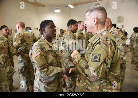 Le Brigadier général Michael N. Cleveland, commandant du 66e commandement de la troupe, secoue la main avec un soldat lors de la cérémonie de remise des prix du COVID à Greenville, Mississippi, le 13 juillet 2021. La Garde nationale du Mississippi a déployé plus de 1,700 gardes pour travailler aux côtés de MSDH et de MEMA afin de lutter contre la propagation du COVID-19 pendant la pandémie. Banque D'Images