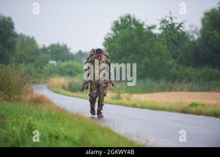 SPC de l'armée américaine. Isaiah Hicks, spécialiste du système de soutien du signal, applique de la peinture de camouflage au sergent de l'armée américaine. William Schofield, tous deux affectés à la 66e Brigade de renseignement militaire, lors d'une compétition de meilleur guerrier dans la zone d'entraînement de Sand Dunes à Wackernheim, Allemagne, le 13 juillet 2021. Le concours de trois jours du meilleur guerrier est conçu pour mesurer la capacité d'un soldat à s'adapter et à surmonter des scénarios et des événements difficiles axés sur la bataille, qui testent leurs capacités techniques et tactiques sous le stress et la fatigue extrême. Banque D'Images