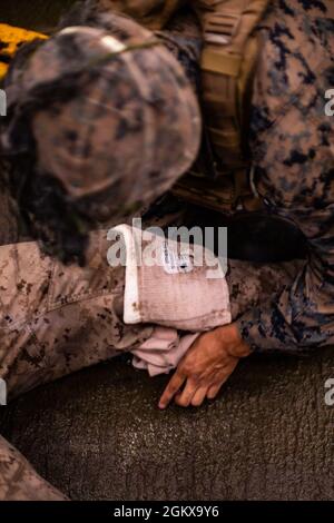 Un pansement de pression est appliqué sur la jambe d'une victime d'entraînement au cours de l'application pratique finale d'une classe d'économiseur de combat (CLS) à bord de l'USS Germantown (LSD 42) dans la mer de Corail, le 16 juillet 2021. La 31e unité expéditionnaire maritime (UMM) opère à bord des navires du groupe de grève expéditionnaire américain dans la zone de la 7e flotte d'opérations afin d'améliorer l'interopérabilité avec les alliés et les partenaires et de servir de force de réaction prête pour défendre la paix et la stabilité dans la région Indo-Pacifique. Banque D'Images