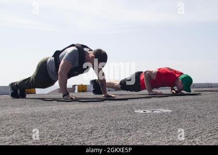 Spécialiste culinaire de 2e classe Tyler Neff, à gauche, de Lehighton, en Pennsylvanie, affecté au département d'approvisionnement de l'USS Gerald R. Ford (CVN 78), et à l'officier d'aviation de 2e classe Benjamin Walden, de Bristol, Tennessee, affecté au département d'entretien intermédiaire d'aéronefs, participent au défi de l'opération Red Wing, le 18 juillet 2021. Le défi de remise en forme rend hommage à la vie de 19 guerriers qui ont fait le sacrifice ultime le 27 juin 2005, dans la province de Kunar, en Afghanistan. Ford est en cours dans l'océan Atlantique en menant des essais de choc à bord d'un navire complet. La marine américaine effectue des essais de choc sur le nouveau navire Desi Banque D'Images