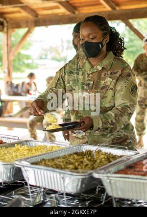 SPC de l'armée américaine. Stephanie Byers, de la 58e Brigade de renseignement militaire expéditionnaire de la Garde nationale du Maryland, se sert de la nourriture pendant la Journée de la famille à fort George G. Meade, Maryland, le 18 juillet 2021. La 58e EMIB a organisé la Journée de la famille pour accueillir les soldats de retour qui sont récemment rentrés chez eux après leur déploiement au Moyen-Orient, ainsi que pour renforcer le moral et construire une camaraderie au sein de l'unité. Banque D'Images