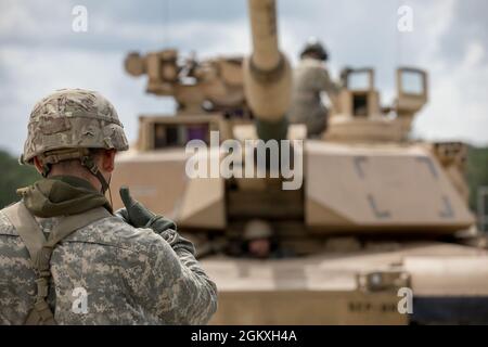 Un étudiant de maître Gunner de l'armée américaine, affecté au 3e Escadron, 16e Régiment Calvaire, utilise des signaux de main et de bras pour diriger un char d'Abrams M1A2 SEP V2 où se déplacer à Ware Range, fort Benning, GA., 20 juillet 2021. Ces pétroliers sont formés pour devenir des mater Gunners et être des experts en la matière dans leur domaine. Banque D'Images