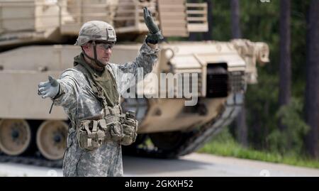 Un étudiant de maître Gunner de l'armée américaine, affecté au 3e Escadron, 16e Régiment Calvaire, utilise des signaux de main et de bras pour diriger un char d'Abrams M1A2 SEP V2 où se déplacer à Ware Range, fort Benning, GA., 20 juillet 2021. Ces pétroliers sont formés pour devenir des mater Gunners et être des experts en la matière dans leur domaine. Banque D'Images