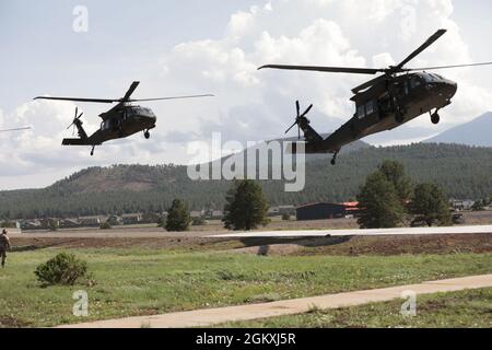 Deux HÉLICOPTÈRES UH-60 Black Hawk arrivent au camp Navajo, en Arizona, pour charger des concurrents et les transporter à la réserve militaire de Florence le 20 juillet 2021. La compétition dure trois jours physiquement et mentalement exigeants où les concurrents sont testés sur une variété de compétences tactiques et techniques alors qu’ils rivalisent pour être nommés soldat de la Garde d’Armée de terre et officier non commandant de l’année. Les gagnants représenteront ensuite la Garde de l'Armée de terre dans le cadre de la compétition des meilleurs guerriers du département de l'Armée plus tard cette année. Banque D'Images