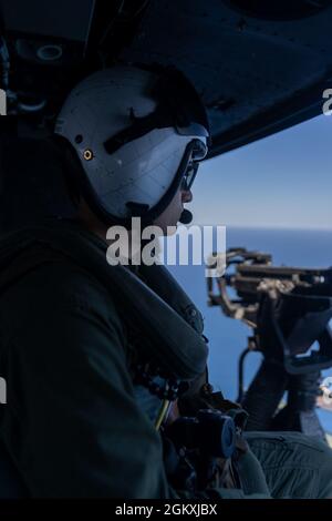 Caporal de lance du corps des Marines des États-Unis Christian Paterson, avec Marine Light Attack Helicopter Squadron 267, Marine Aircraft Group 16, 3e Escadre Marine Aircraft Wing (MAW), arpente l'océan Pacifique pour trouver des navires ennemis simulés lors de l'Advanced Naval BASING Evolution of Summer Fury 21 à San Clemente, Californie, le 20 juillet 2021. Base navale avancée offrant une logistique et un soutien avant-garde, ainsi que des capacités de détection et de frappe qui contribuent de manière significative aux campagnes de guerre sous-marine dans la région Indo-Pacifique. Summer Fury est un exercice mené par le 3e MAW afin de maintenir et de renforcer les capacités, Banque D'Images