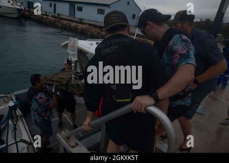Des bérets verts de l'armée des États-Unis avec le 2e Bataillon, 1er Groupe des forces spéciales (Airborne), déplacent un patient de litière simulé sur un bateau pour l'évacuation des victimes pendant l'opération Forager 21 à Saipan, Commonwealth des îles Mariannes du Nord, le 20 juillet 2021. Forager 21 est une armée américaine du Pacifique Banque D'Images