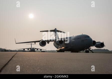 Les avions C-17 Globemaster III avec la 167e Escadre de transport aérien attendent leur prochaine mission sur la ligne de vol à la base de la Garde nationale aérienne de Shepherd Field, Martinsburg, Virginie-Occidentale, le 20 juillet 2021. Le C-17 est l'avion cargo le plus flexible de la force de transport aérien, capable d'effectuer des missions de livraison de troupes et de fret, de transport aérien tactique et de dépôt aérien, ainsi que le transport de patients pendant les évacuations aéromédicales. Banque D'Images