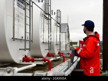 Le sous-officier de 2e classe Craig Bennett, technicien en sciences de la mer du Groupe de travail sur la sécurité maritime de la Garde côtière, inspecte une installation de stockage de mazout à Teller, en Alaska, le 20 juillet 2021. Dans le cadre de l'inspection, les membres du FSTM discutent des plans d'intervention, examinent la documentation et inspectent l'équipement et les installations de stockage du carburant afin d'assurer la conformité réglementaire. Banque D'Images