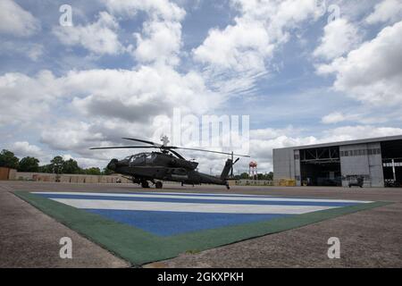 Un hélicoptère Apache AH-64E se trouve à l'extérieur d'un hangar comme soldats du 3e Escadron, du 17e Régiment de cavalerie, de la 3e Brigade de l'aviation de combat, de la 3e Division d'infanterie, qui mènent un entraînement de récupération d'aéronefs en vol à l'aérodrome de l'Armée Hunter, en Géorgie, en juillet 21. La formation de l'équipe de récupération des aéronefs à temps réduit permet aux soldats de maintenir leurs compétences tactiques au travail et de maintenir leur état de préparation à l'unité. Banque D'Images