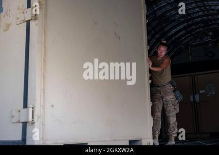 Un Airman de la Force aérienne des États-Unis affecté au 443e Escadron de mobilité aérienne expéditionnaire décharge la cargaison au cours d'une mission à l'appui de la Force opérationnelle interarmées combinée - opération inhérente Resolve, dans la zone de responsabilité du Commandement central des États-Unis, le 21 juillet 2021. Le CJTF-OIR permet à ses partenaires d'assurer la défaite durable de l'EI dans des zones désignées d'Irak et de Syrie et fixe les conditions pour des opérations de suivi visant à accroître la stabilité régionale. Banque D'Images